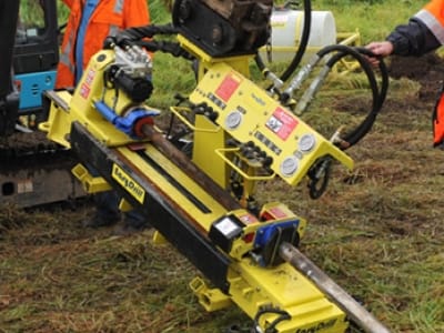 Gele gestuurde boorinstallatie met bedieningspaneel aan het werk in een veld